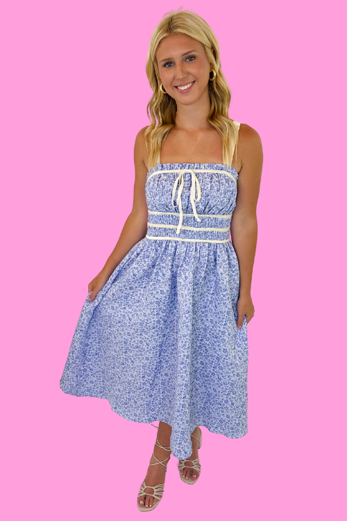 Blue micro floral jacquard print Stretchy adjustable shoulder strap Square neckline with self tie at bust Gathered smocking on chest and back Velvet trim detailing Side pockets Relaxed fit bodice Unlined, non-sheer 81% Polyester, 19% Nylon Model is wearing a size small