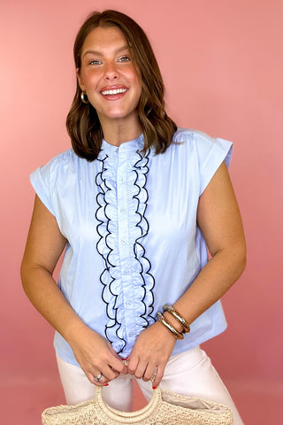 light blue top with ruffled details down chest