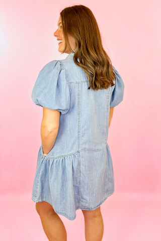 Lightwash denim dress with button down front, puff sleeves, and side pockets. Concert dress. summer dress. casaul dress.