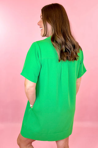 relaxed fit dress is green with short sleeves, fold over collar, gold button detailing on the chest, and side pockets. summer dress.easter dress. beach dress